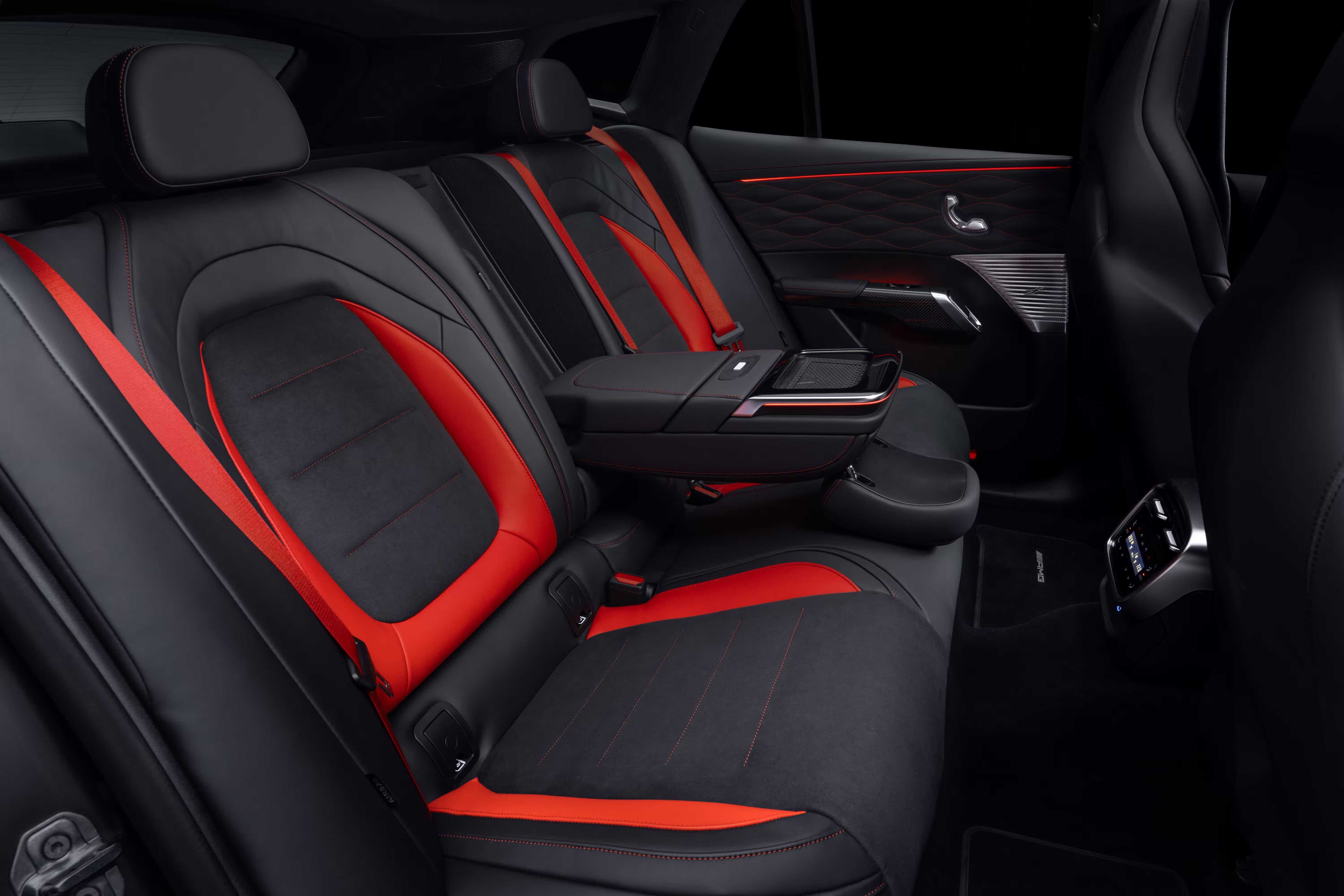 Banco traseiro do Mercedes-AMG GT SUV com apoio central abaixado e cintos vermelhos