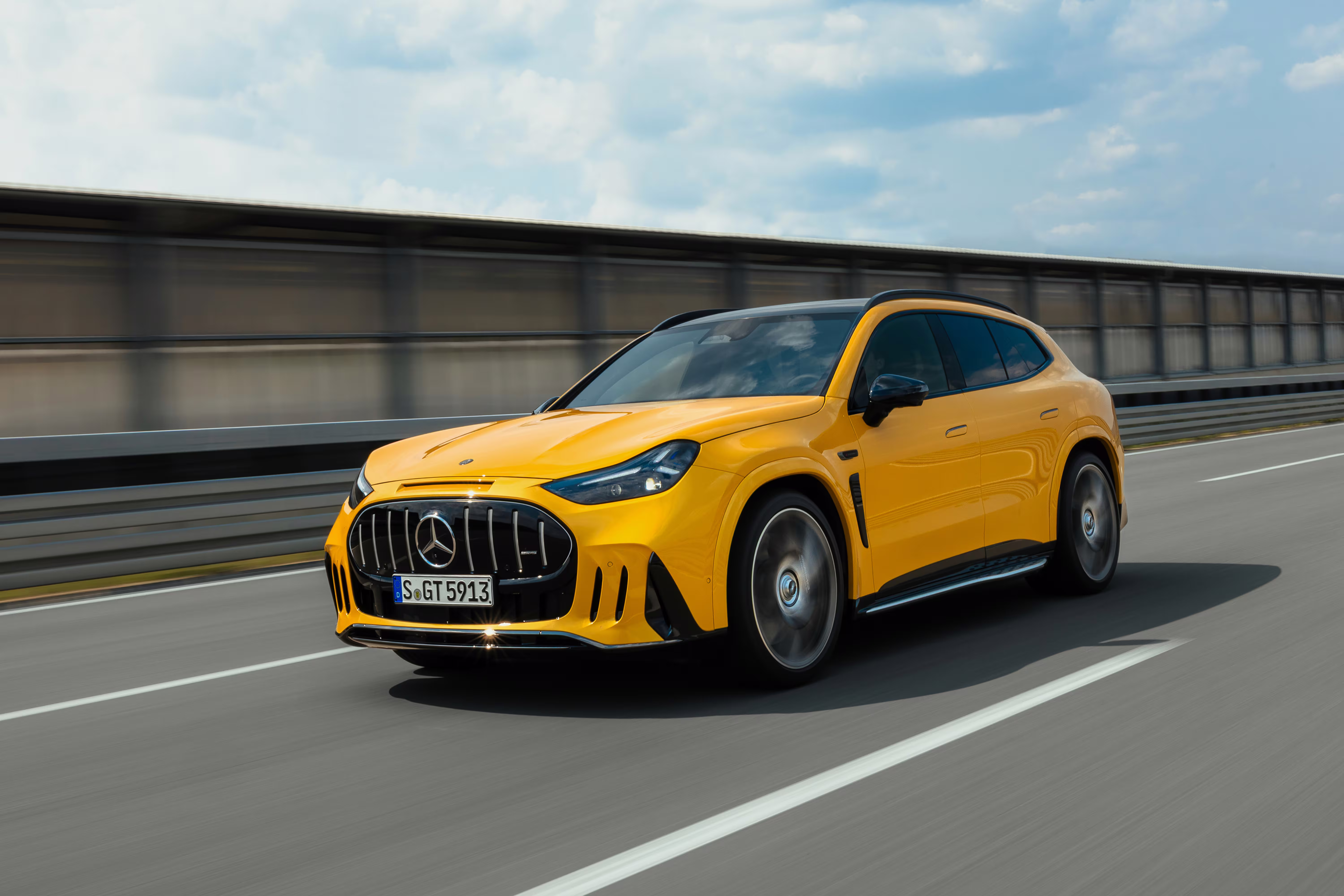Mercedes-AMG GT SUV amarelo em movimento com a frente à esquerda da imagem