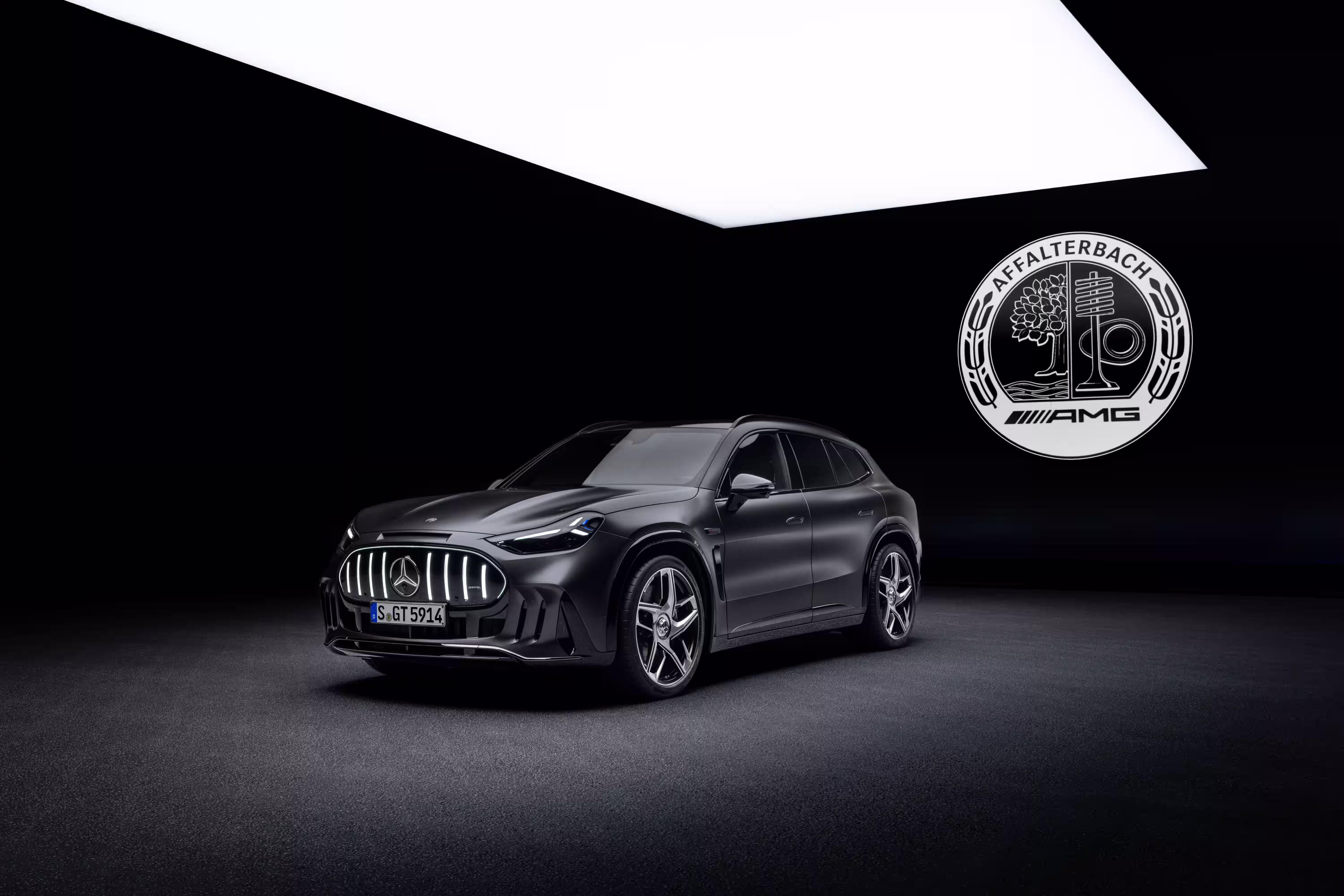 Mercedes-AMG GT SUV cinza sob iluminação de estúdio com emblema AMG ao fundo