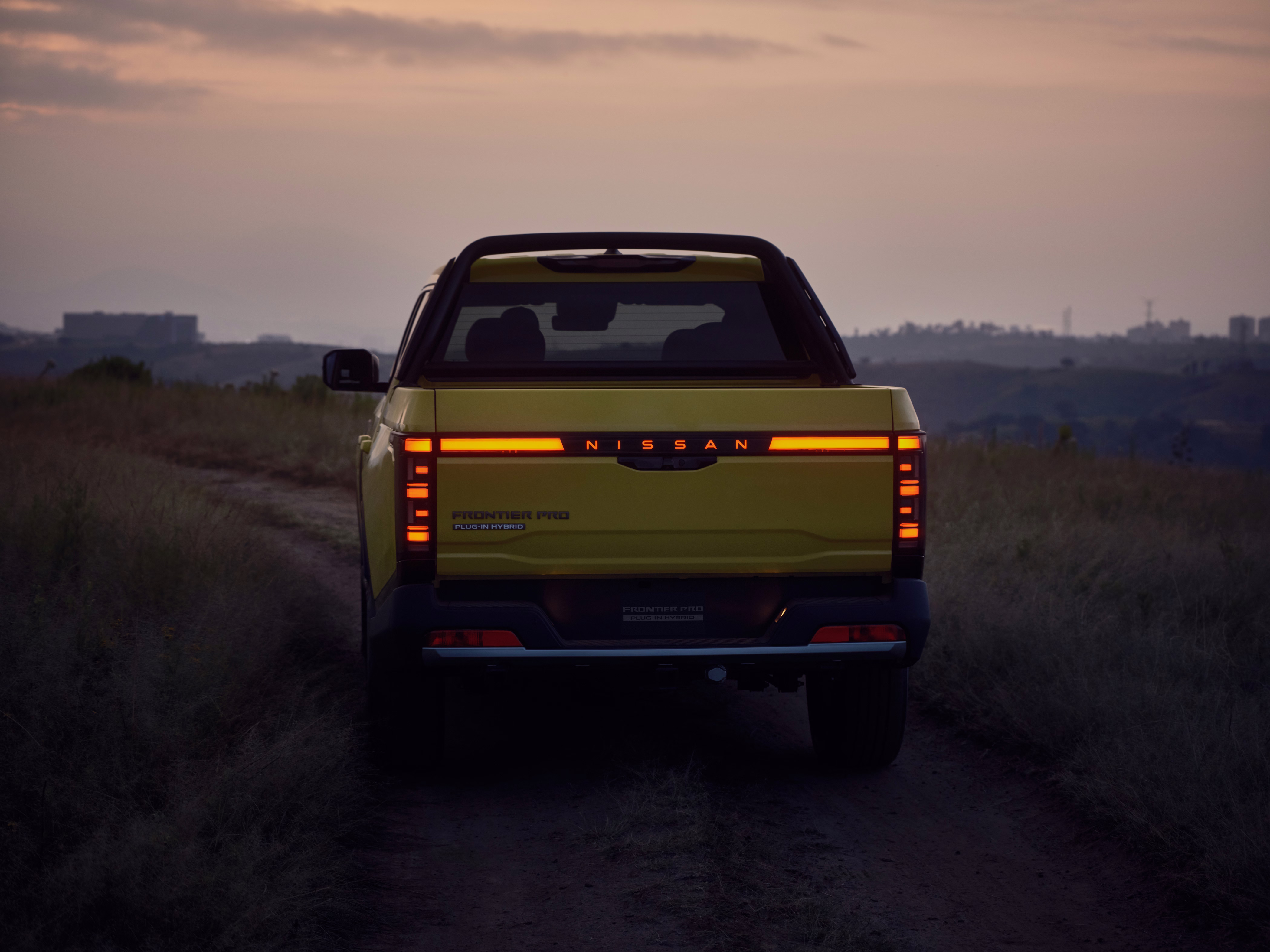 Traseira da Frontier Pro com barra luminosa acesa ao entardecer