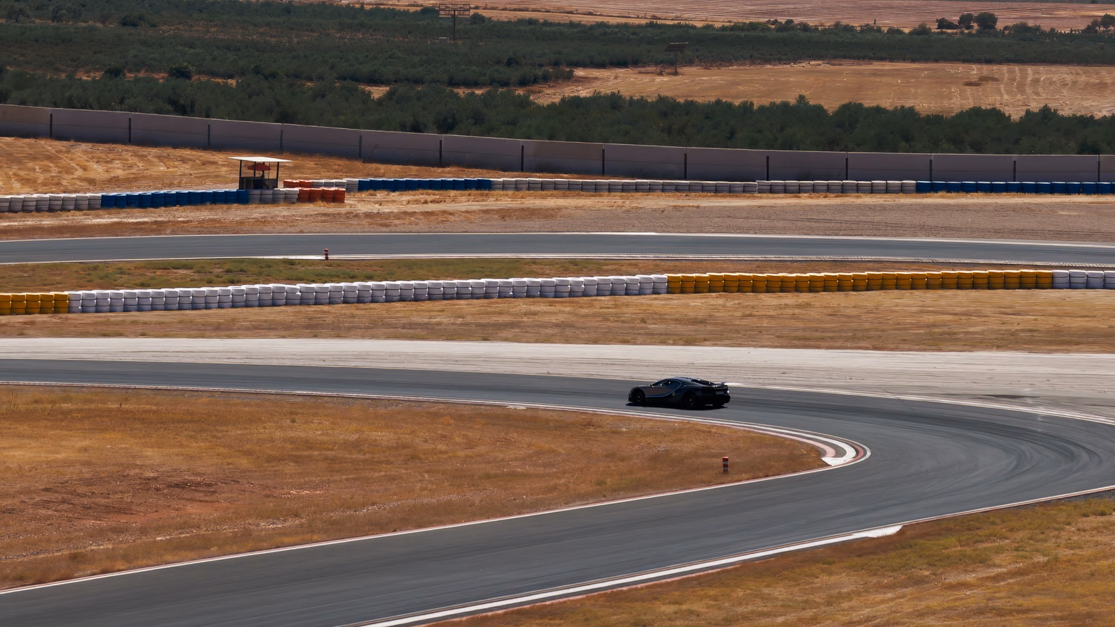Protótipo do Bugatti Tourbillon percorre curva do circuito entre áreas de vegetação seca