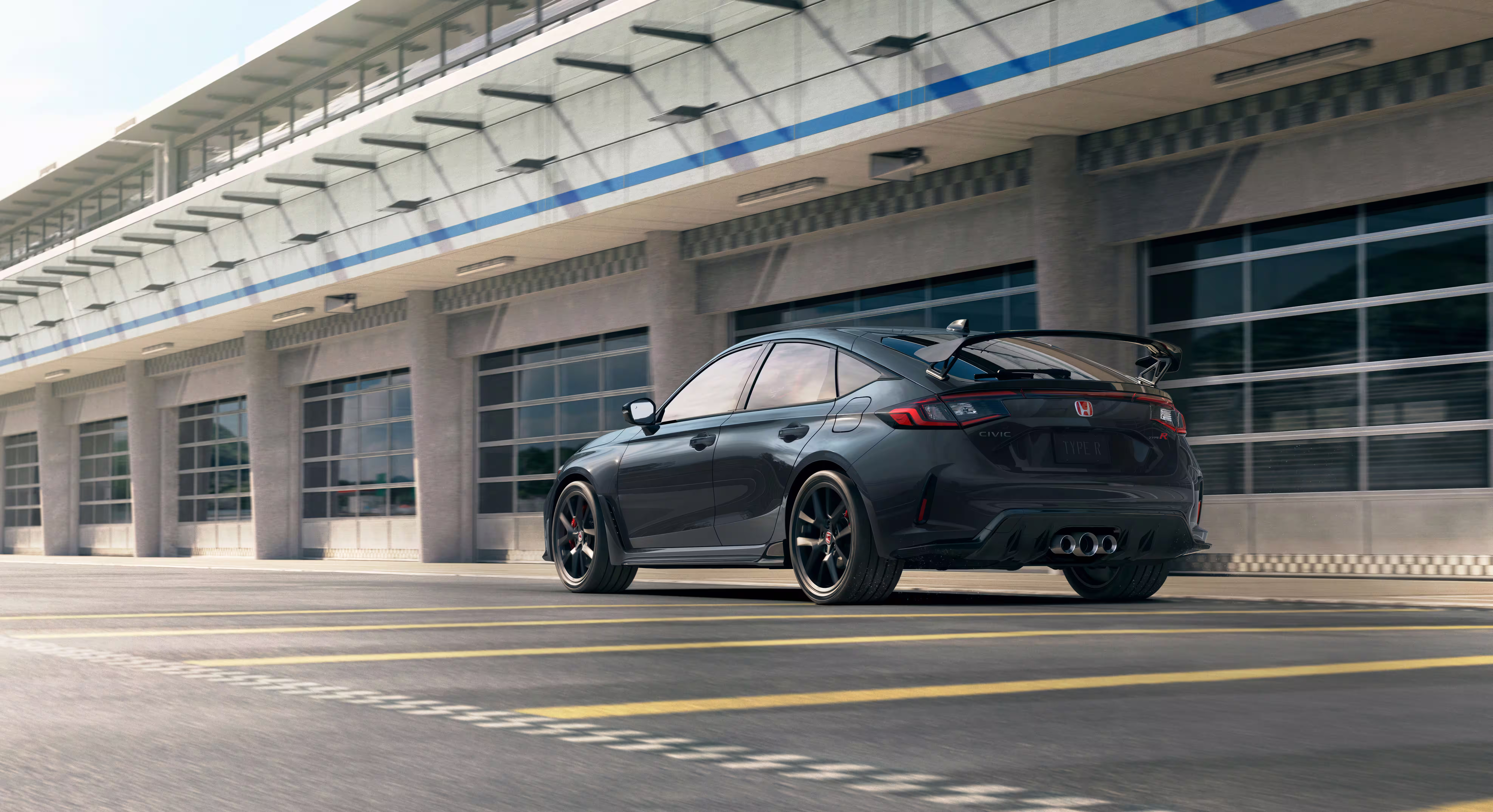 Honda Civic Type R 2027 cinza visto em três quartos traseiros junto aos boxes