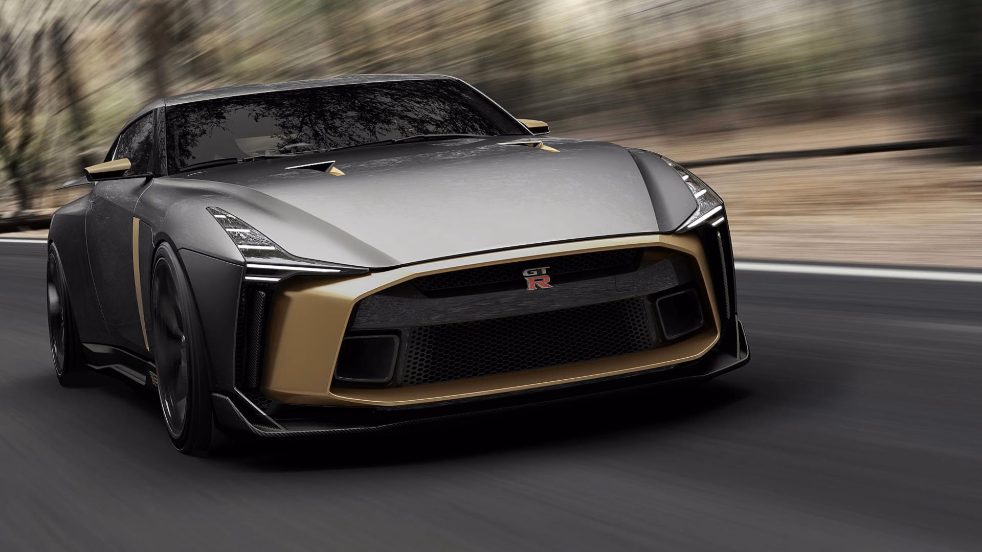 Nissan GT-R50 cinza e dourado em movimento visto em três quartos dianteiros