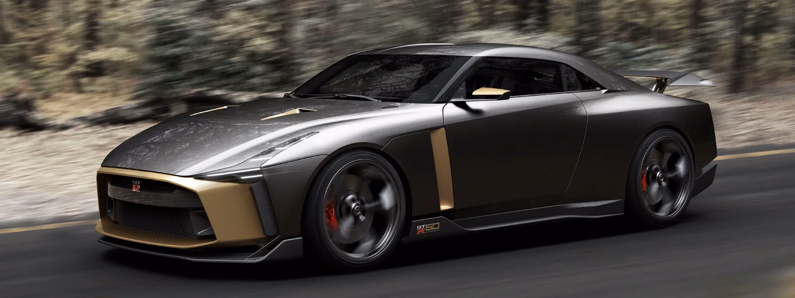 Enquadramento panorâmico lateral dianteiro do GT-R50 cinza e dourado em movimento