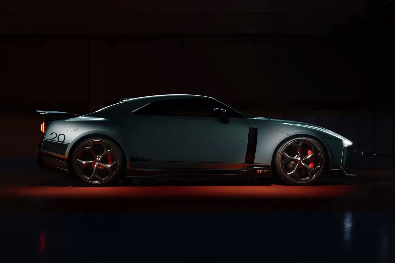 GT-R50 verde-claro de perfil em estúdio com iluminação vermelha