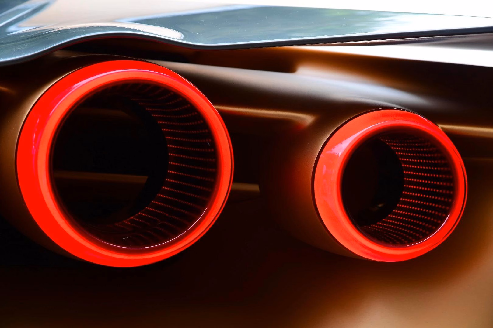 Close de duas lanternas circulares do GT-R50 com anéis vermelhos e centros vazados